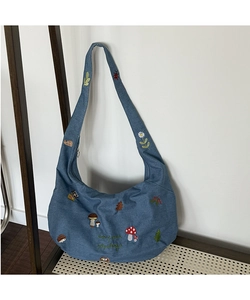 Détails de broderie nature avec champignons et hérissons sur le sac en jean bleu