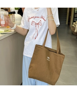 Detailed view of the brown canvas tote bag with TRUBAG logo showing large capacity size