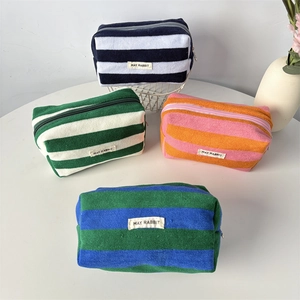 Detailed view of striped plush pencil cases with zipper and May Rabbit brand tags