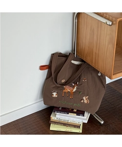 Close-up of forest embroidery on large brown canvas tote bag with stag and mushroom
