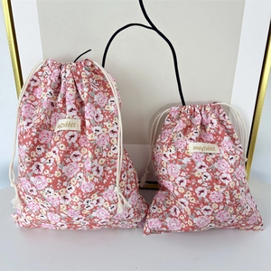Detail of pink floral drawstring storage bags in two sizes with cotton rope closure