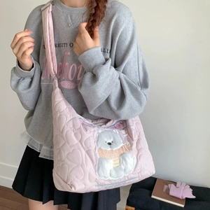 Detail of pink quilted tote bag featuring a plush 3D bear patch and heart stitching