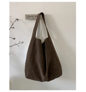 Detail of minimalist suede tote bag in dark brown with seamless stitching texture