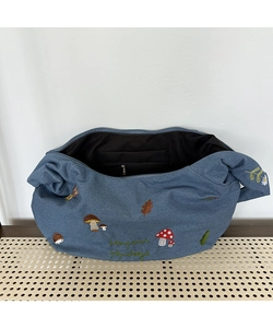 Détail de la broderie forêt sur sac en jean avec motifs de hérisson et de champignons