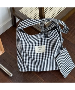 Detail view of gingham canvas tote bag set with matching pouch on vintage wood floor