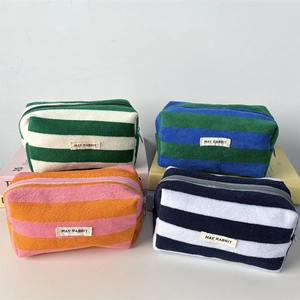 Close-up of soft striped terry cloth pencil cases with zipper and brand label