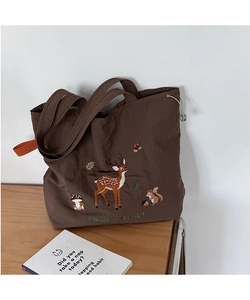 Detail of forest embroidery on dark brown canvas tote bag with adjustable drawstring closure
