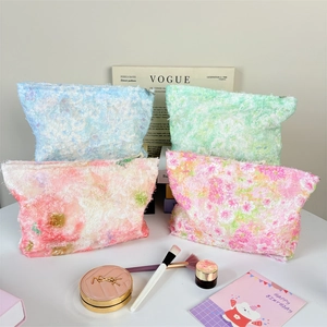 Detailed stack of plush floral toiletry bags in blue, green, and pink with metal zippers