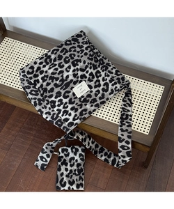 Detailed set of leopard print canvas tote bag with matching zipper pouch on woven bench