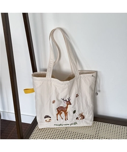 Detailed close-up of forest animal embroidery and grey drawstring on canvas tote bag