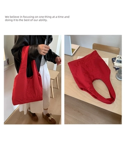 Detail of red nylon tote bag featuring Never Say Goodbye embossed text in macro view