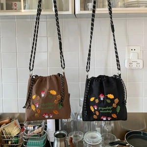 Nylon crossbody bags in black and brown with mushroom embroidery and woven straps