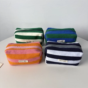 Detail of four striped towel fleece pencil cases in various colors with zippers
