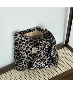 Detail of leopard print canvas tote bag featuring interior lining pocket and magnetic closure