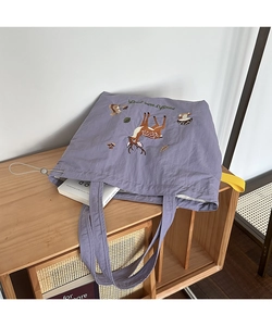 Detail of lavender tote bag featuring animal embroidery and white drawstring closure
