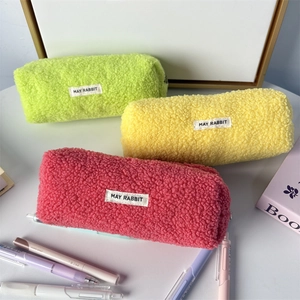 Detailed close-up of neon plush pencil cases with zipper and embroidered labels