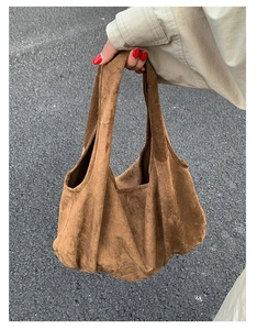 Detail of soft brown suede hobo tote bag showing its natural drape and minimalist texture