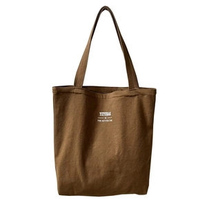 Deep brown canvas tote bag with long handles and white artistic text for daily use