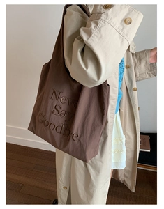 Detailed view of 3D letter embroidery on deep brown nylon tote bag for women