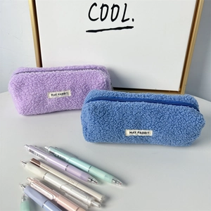 Detail view of plush teddy fleece pencil cases in lavender and blue with zipper closure