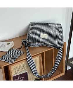 Detail of checkered canvas tote bag with a matching small zipper pouch on a wooden surface