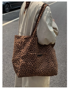 Outdoor street view of a large leopard print tote bag with a functional front pocket