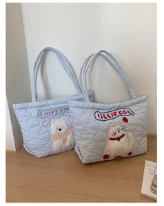 Detailed view of quilted heart patterns and plush animal patches on blue tote bags