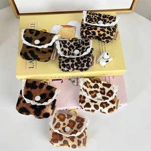 Dettaglio di custodie per auricolari in velluto leopardato con pizzo e gancio giallo