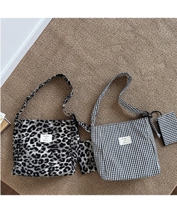 Close-up of canvas tote bag with leopard print and checkerboard patterns and small pouches