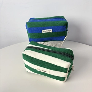 Close-up of striped towel cloth pencil case with zipper and May Rabbit label