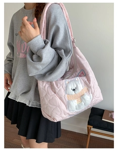 Detail of pink quilted heart tote bag featuring embroidered polar bear and Happy text