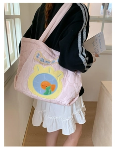 Close-up of pink quilted tote bag featuring heart patterns and cute goldfish embroidery