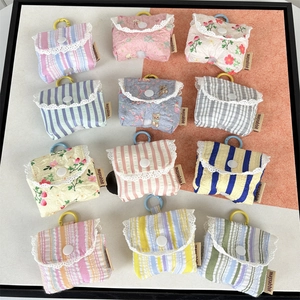 Detail view of quilted earphone pouches with lace edges and various floral stripe patterns