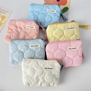 Vue à plat de pochettes matelassées colorées aux motifs floraux avec fermetures en coton
