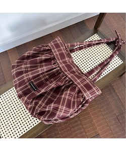 Détail d'un grand sac cabas à carreaux bordeaux avec tissu plissé et nœud décoratif