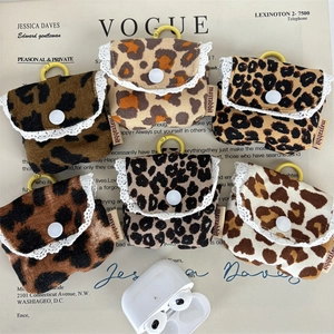 Dettaglio di sei mini borse per auricolari leopardate con pizzo bianco e ganci dorati