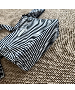 Close-up of black and white gingham tote bag showing fabric texture and woven brand label