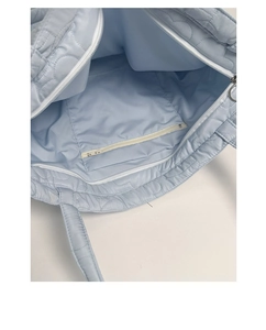 Interior view of light blue quilted tote bag showing main compartment and inner zipper pocket