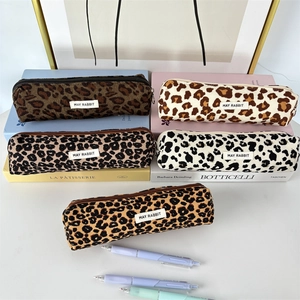 Detail shot of vintage corduroy leopard print pencil cases with metal zippers on art books