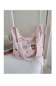 Detail of pink quilted tote with heart stitching and cute puppy cartoon embroidery