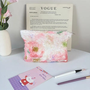 Detail of multi-color plush makeup bag with metal zipper and woven brand label