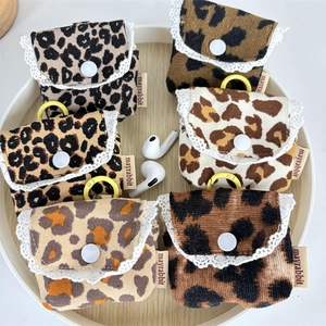 Dettaglio di custodie per auricolari in velluto a coste leopardato con bordo in pizzo