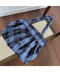 Gros plan sur le sac cabas à carreaux bleus avec texture froncée et étiquette Romance