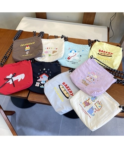 Macro shot showing colorful canvas bags with cute animal embroidery and drawstring closure