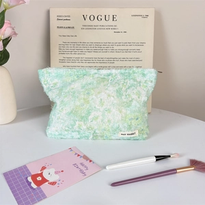Detail of floral plush makeup bag with tassel texture and May Rabbit brand label