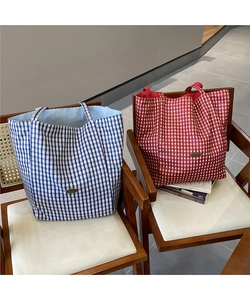 Detail of checkered canvas tote bag interior and handmade label on soft brown fabric