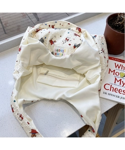 Interior detail of cartoon canvas tote showing zipper pocket and bubble fabric texture