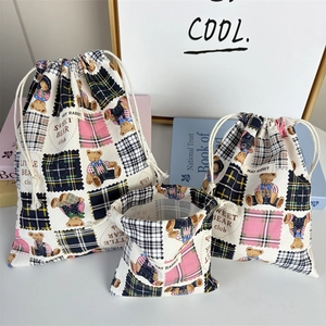 Detailed view of three-piece bear canvas drawstring bags showing textures and sizes