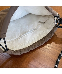 Detail view of large brown canvas bag interior with light cotton lining and zipper pocket