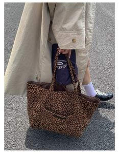 Detailed view of leopard print canvas tote bag with front pocket in street style setting
